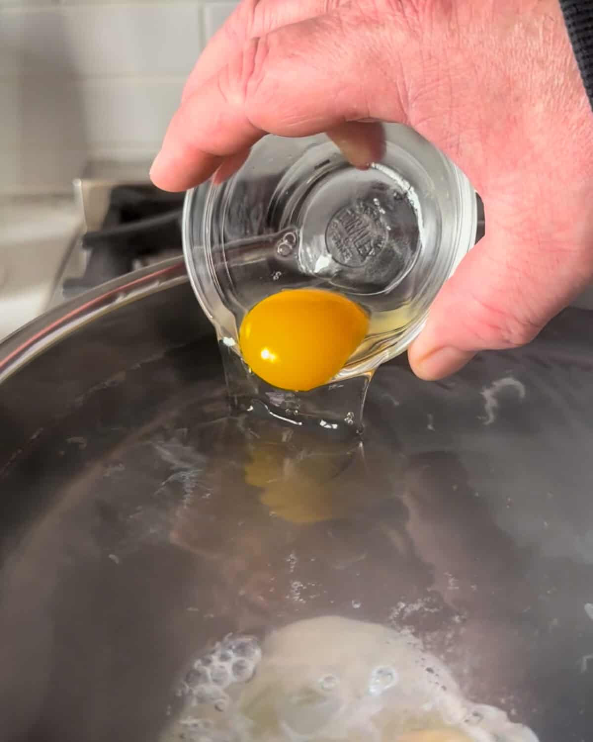 Crack the eggs into small bowls or ramekins, then pour them into the water.