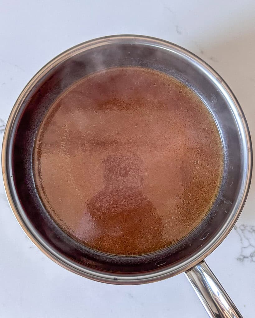 Strained beef broth gravy in a pot.