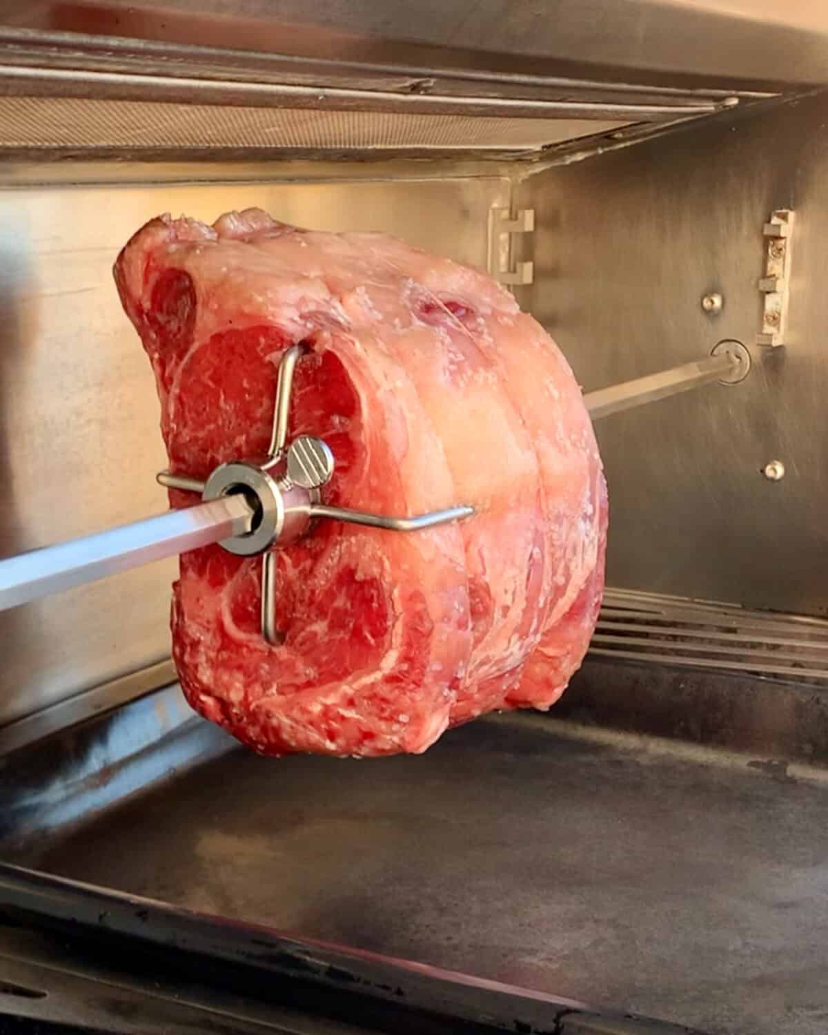 Place the roast on the rotisserie to cook.