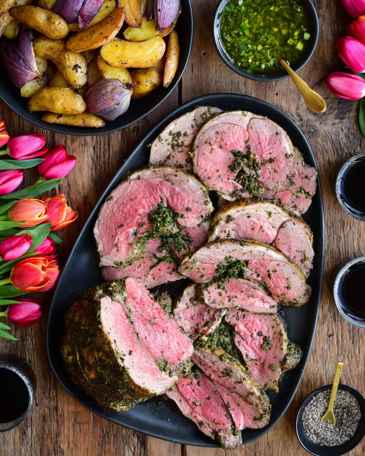 Herb Stuffed Boneless Leg of Lamb served with a fresh mint sauce and roasted potatoes and onions.