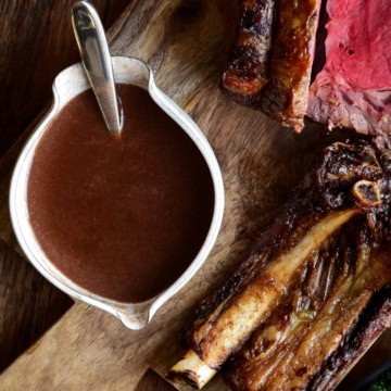 A bowl of homemade beef broth gravy served with prime rib.