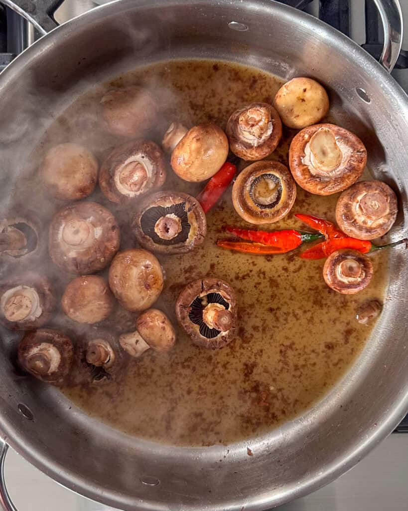Add the butter to the pan, then the chilies, and the mushrooms.