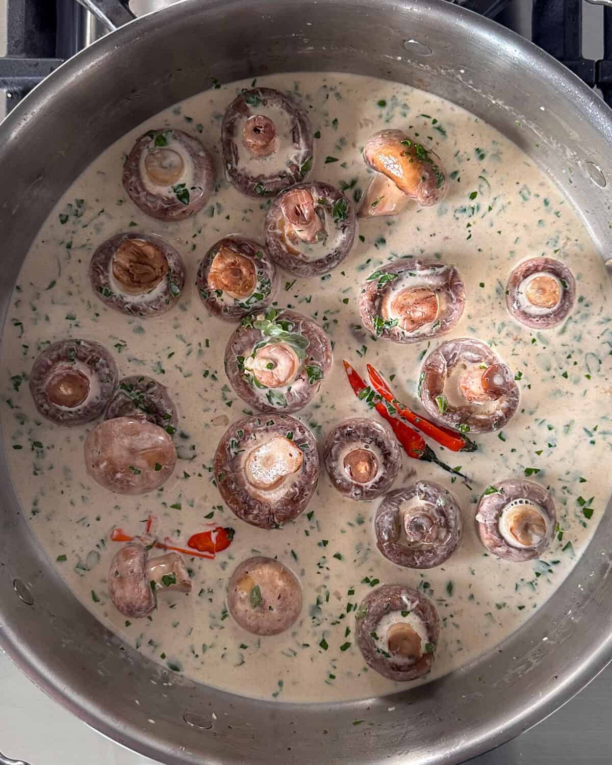 Add the garlic to the pan, stir, and cook for 2 minutes. Pour in the cream, then add the parsley and thyme. Reduce heat to low.