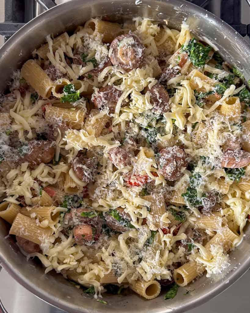 Sprinkle the mozzarella and parmesan cheese evenly over the pasta and mushroom mixture.