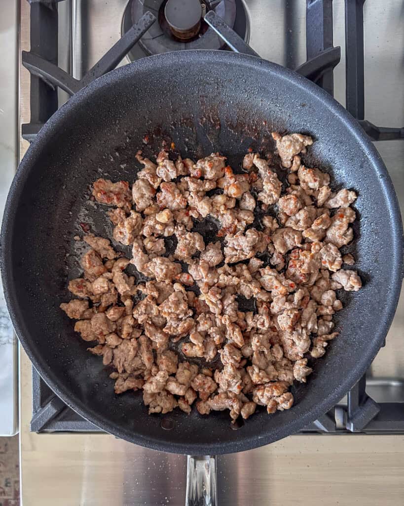 Brown the ground sausage in a skillet.