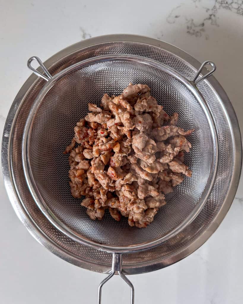 Strain the grease from the sausage meat.