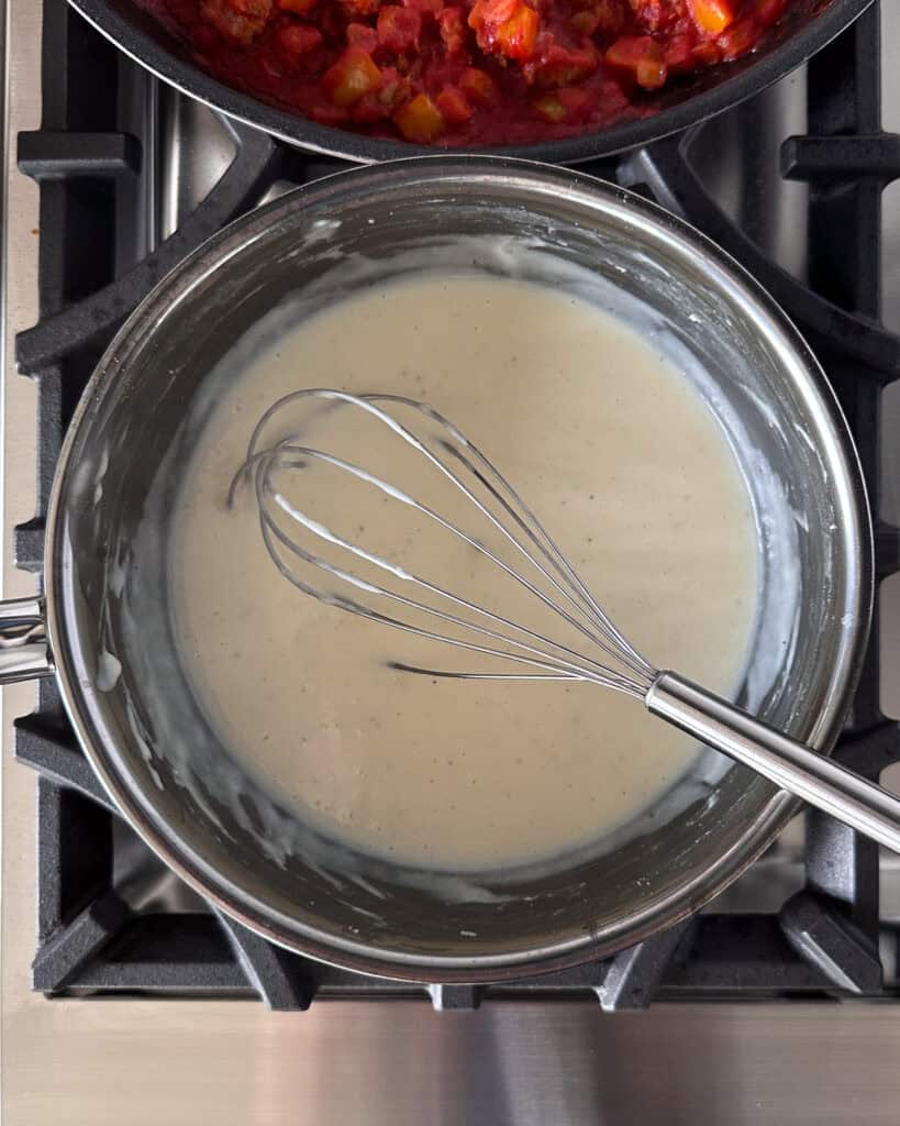 Whisk Béchamel Sauce to remove lumps.