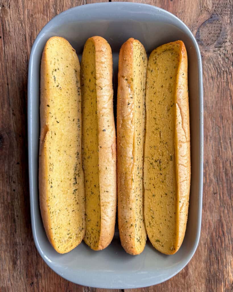 Place the top and bottom halves of the Furlani garlic loaves into a baking dish to form 2 tight V-shapes.