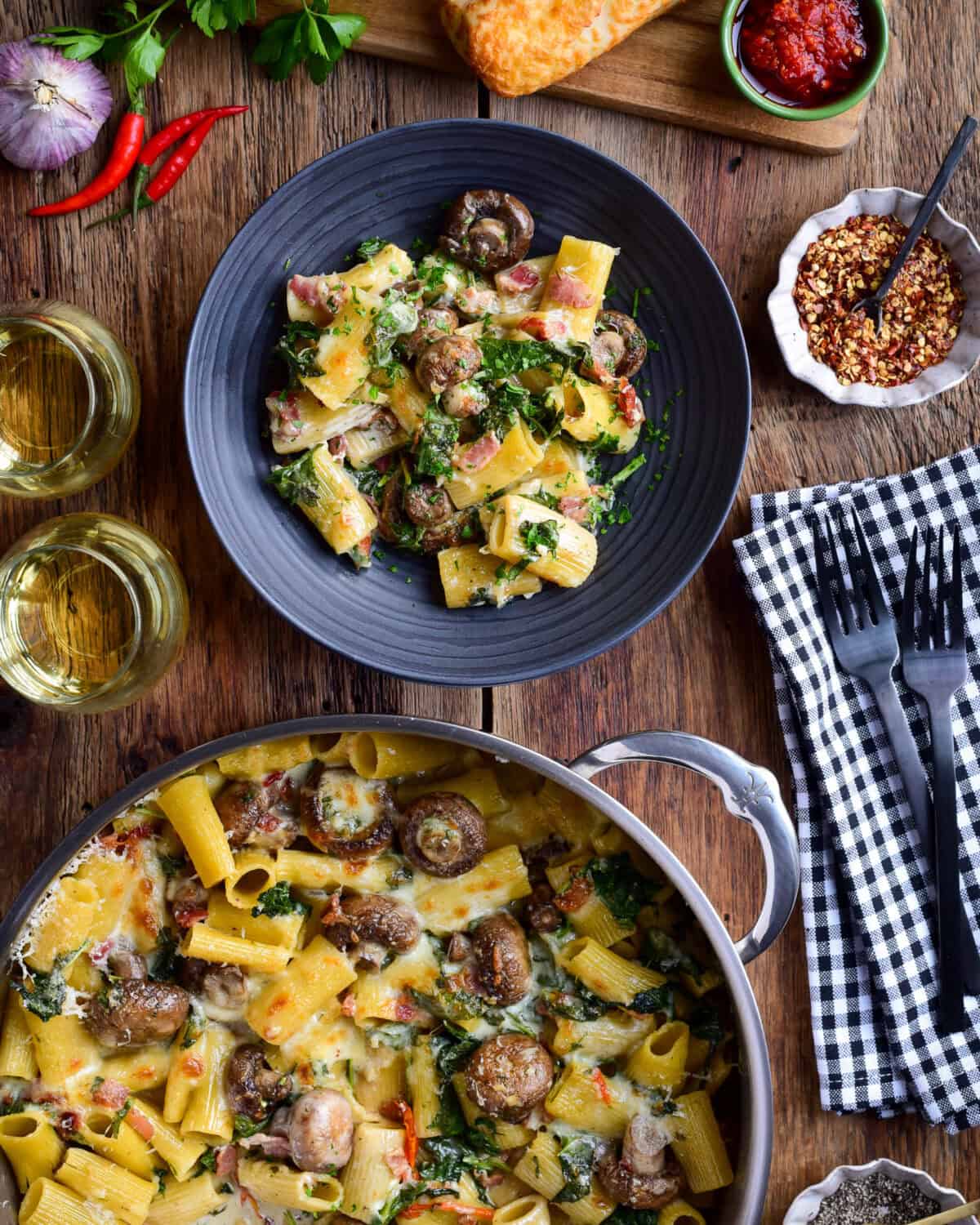 A bowl an pot filled with a Creamy Mushroom Pasta Bake.