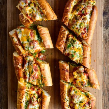 Two loaves of Lasagna Stuffed Garlic Bread cut into pieces.