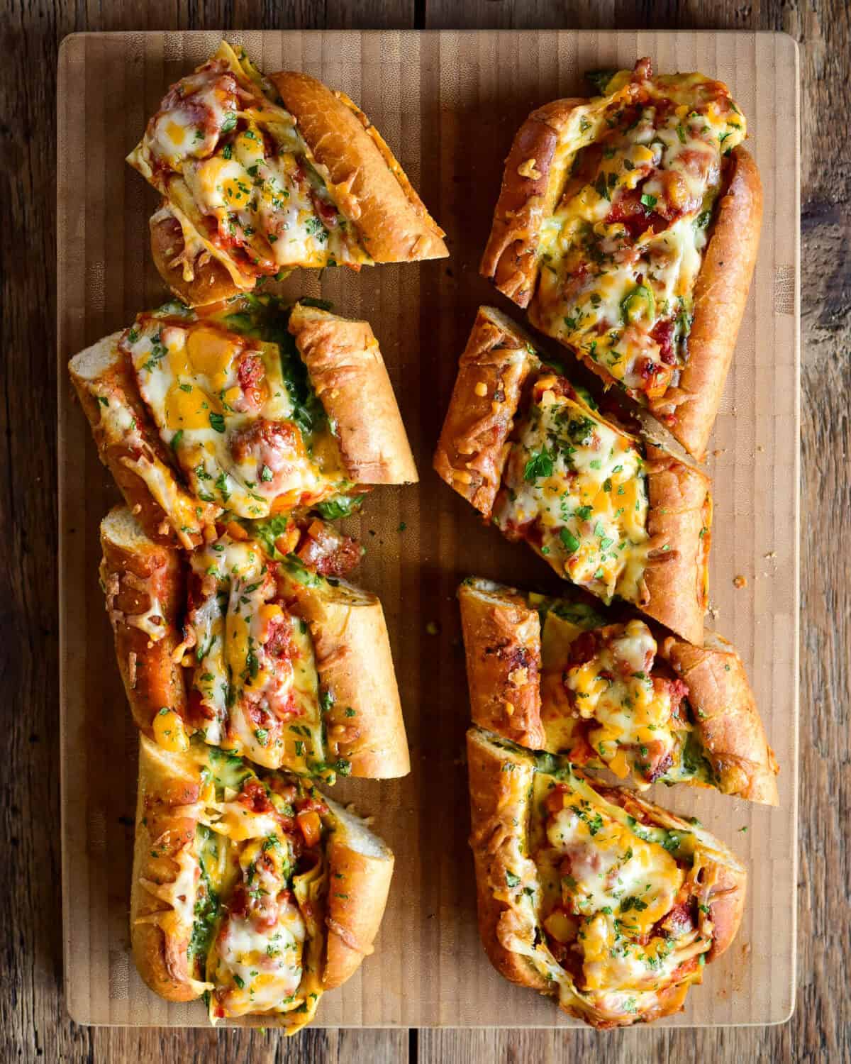 Two loaves of Lasagna Stuffed Garlic Bread cut into pieces.