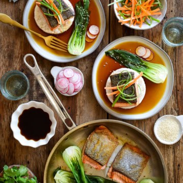 Salmon with Ponzu Sauce served on two plates with rice and bok choy served with fresh vegetable garnishes.