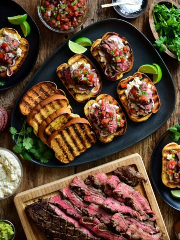 A platter of Flank Steak with Street Corn Mayo on Garlic Toasts.