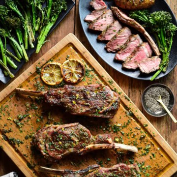 Three Tuscan style veal chops on a cutting board with sauce. A sliced chop is served with a potato and broccolini.