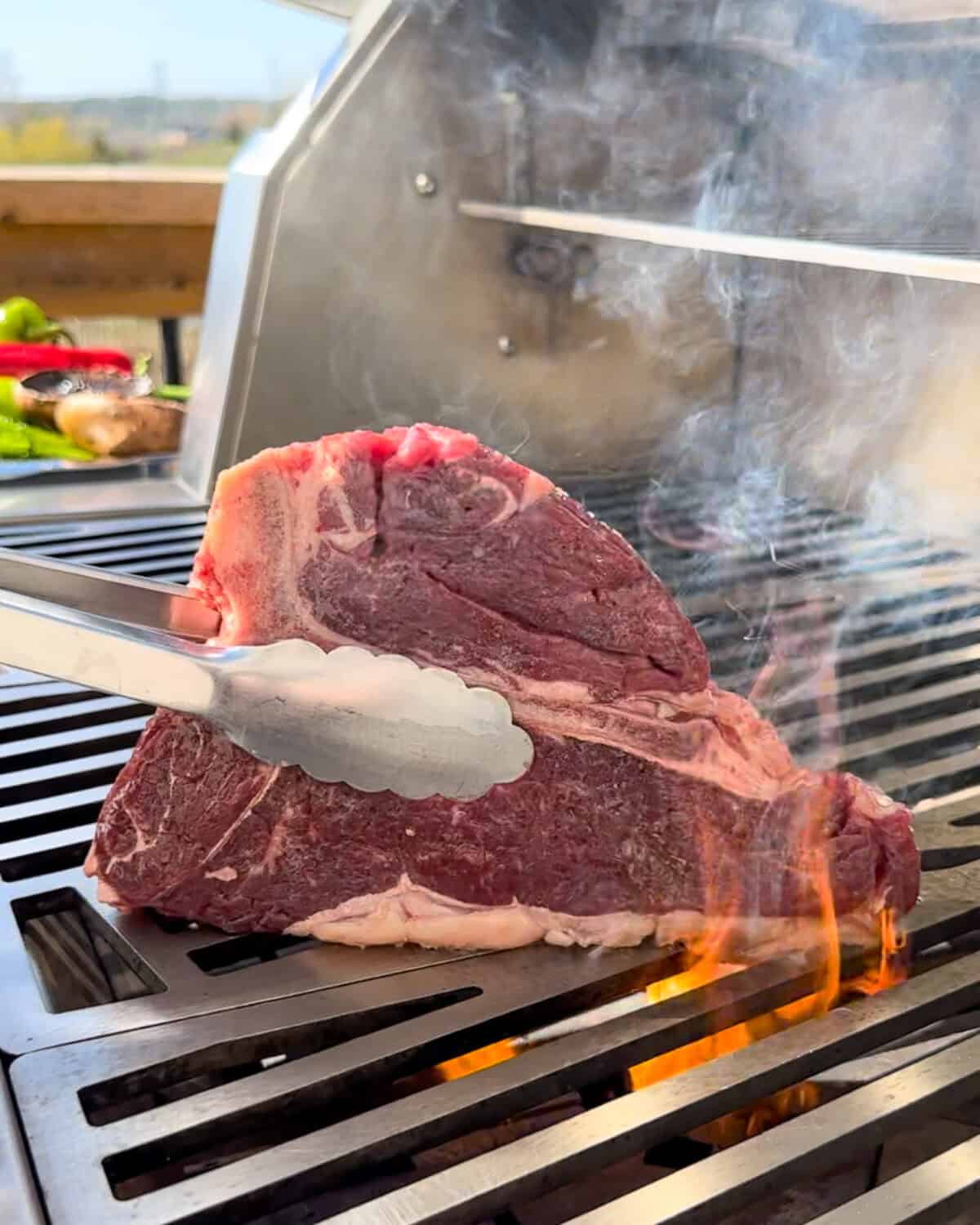 Place the steak, fat edge down, onto the hot grill and sear the fat for 60 to 90 seconds.