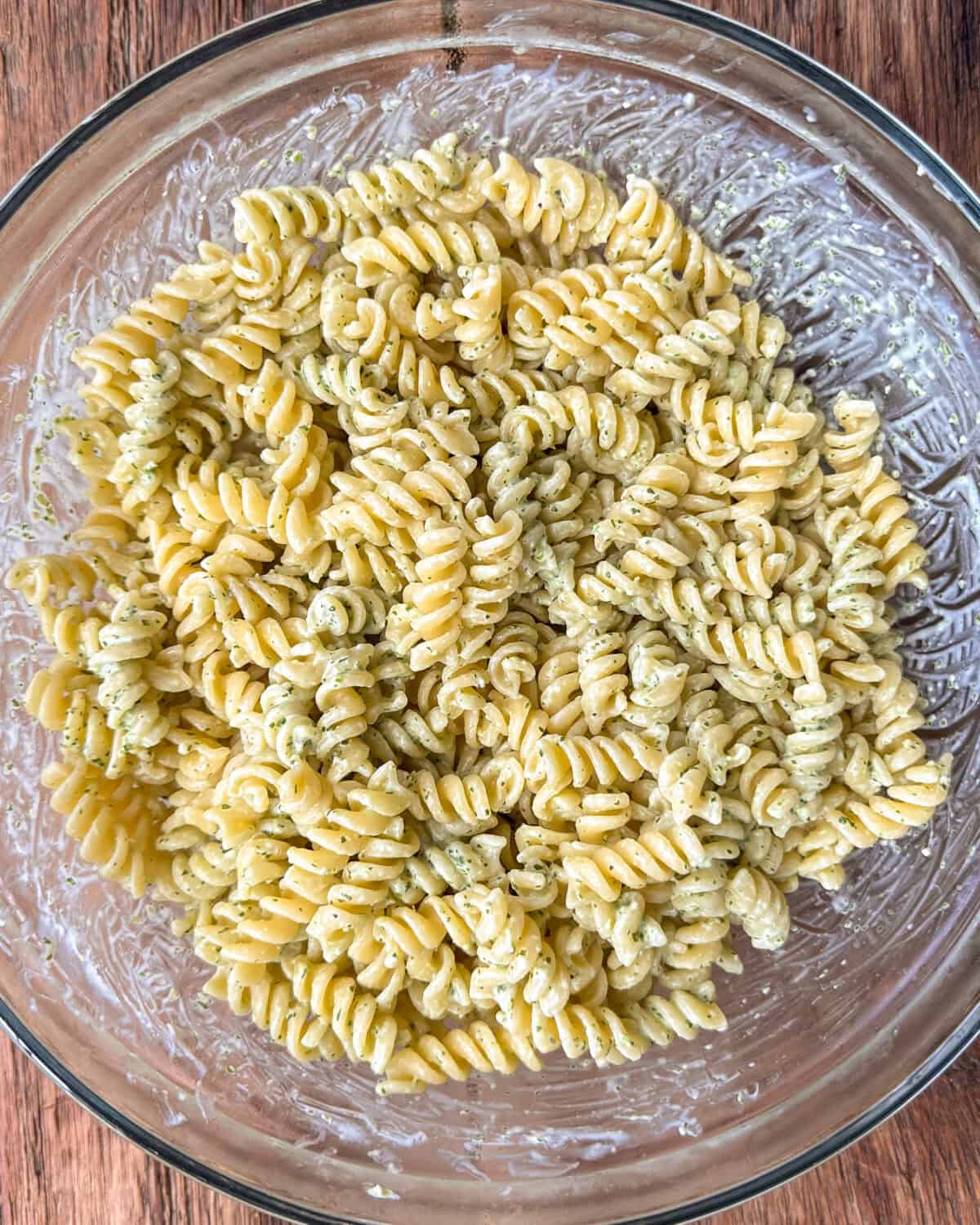 In a large bowl, toss together the hot pasta with the Grana Padano and half the dressing.