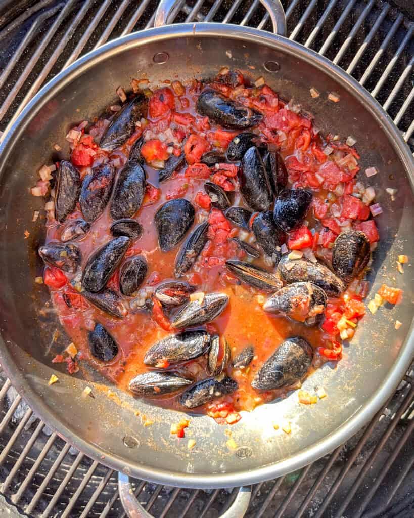 Add the mussels to the broth to steam.