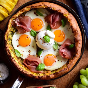 A savory Dutch baby pancake with four fried eggs, proscuitto, burratta and fresh basil.
