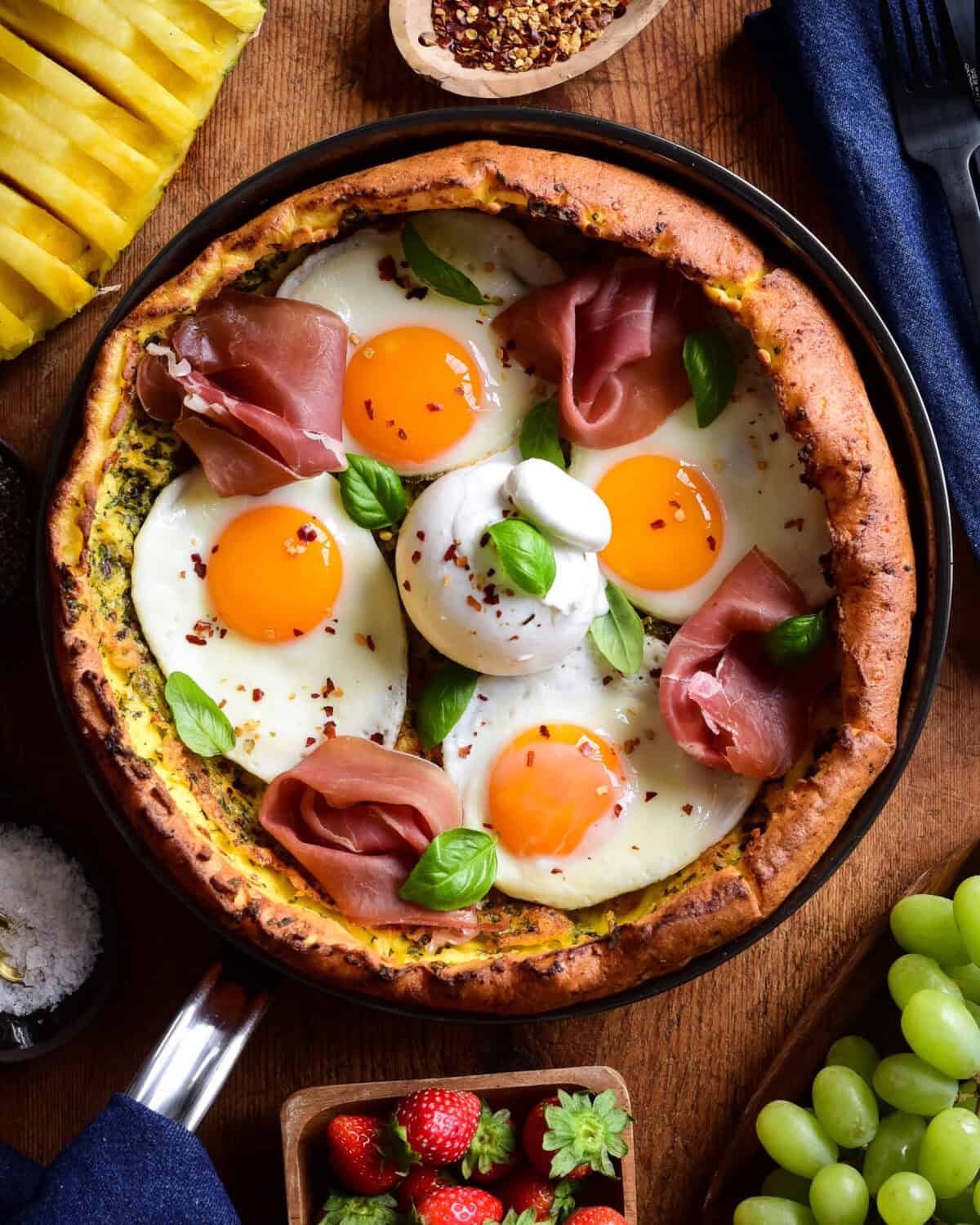 A savory Dutch baby pancake with four fried eggs, proscuitto, burratta and fresh basil.