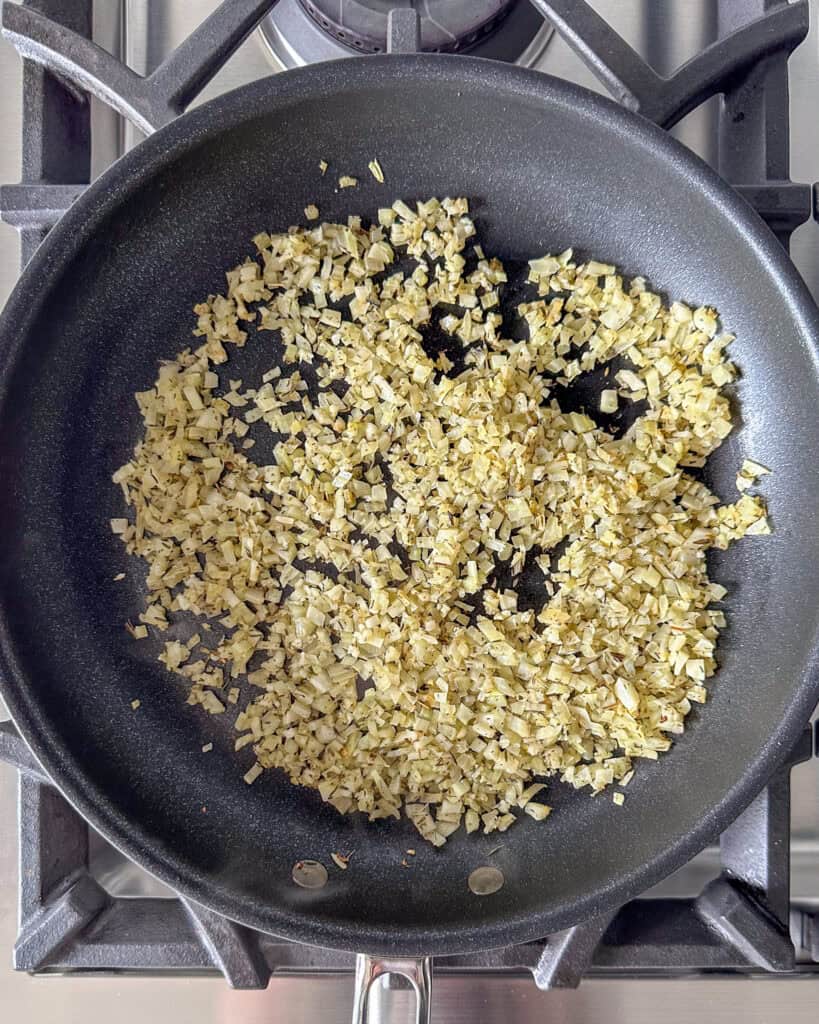 A pan cooking diced fennel, thyme and garlic.
