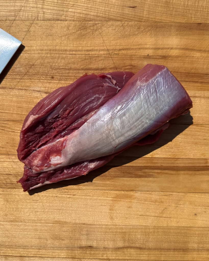 Begin by gently pulling the veal butt tenderloin apart with your fingers.