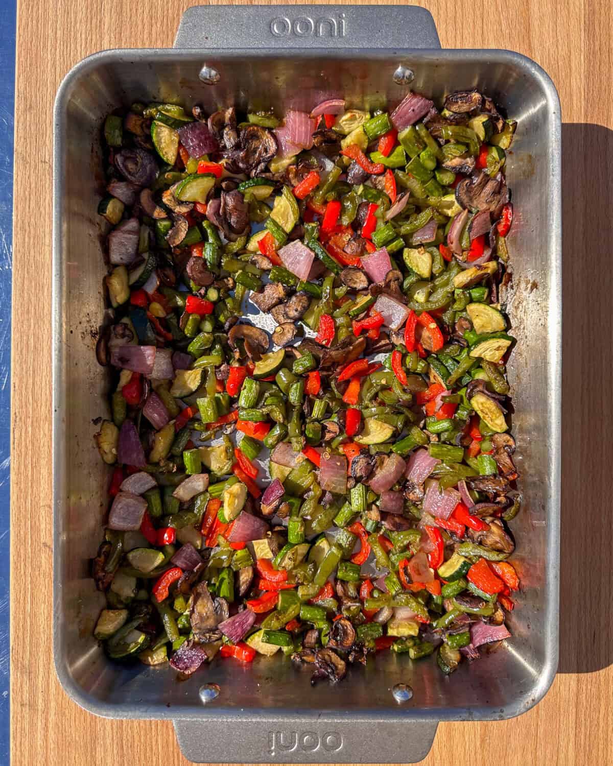 A roasting pan with roasted cut vegetables for a spicy vegetable lasagna.
