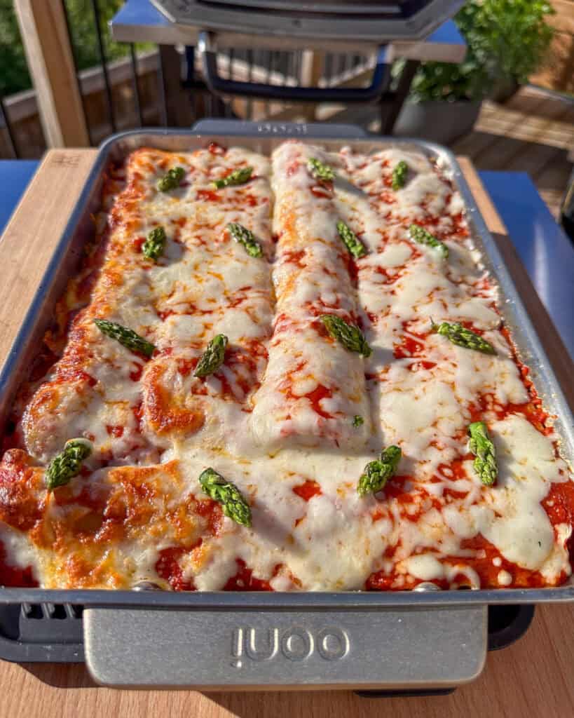 A cheesy lasagna with asparagus tips on the cheese.