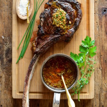 A perfectly grilled long bone ribeye with cowboy butter.