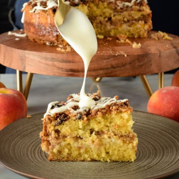 A slice of Air Fryer (Peach) Coffee Cake getting drizzled with icing with the cake in the background.