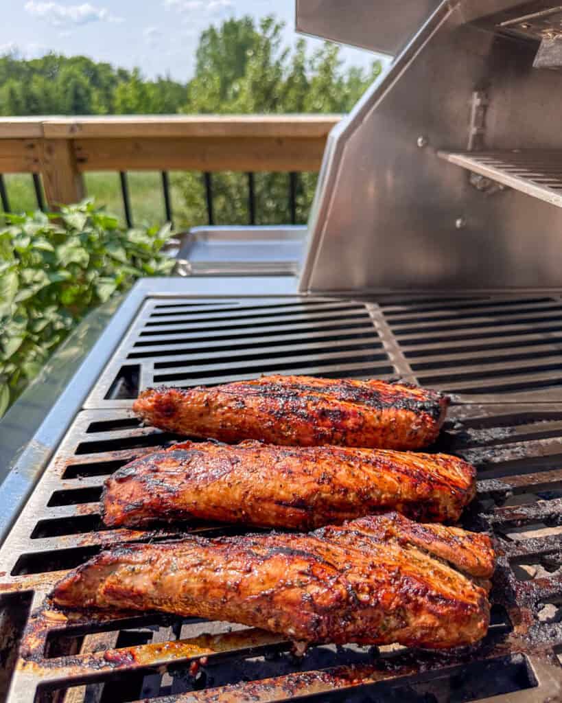 Three grilled pork tenderloins on the grill.