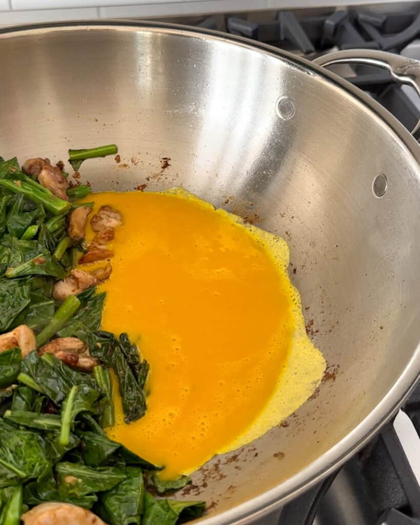 Scrambling eggs on one side of the grill with a stir fry on the other side.