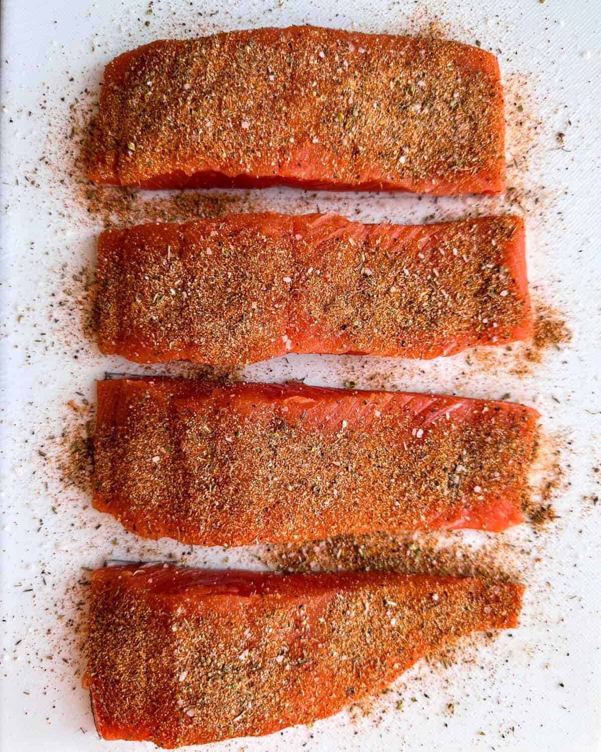 Rub the top/flesh side of each portion of salmon with 1 teaspoon of the spice mixture. Set aside.