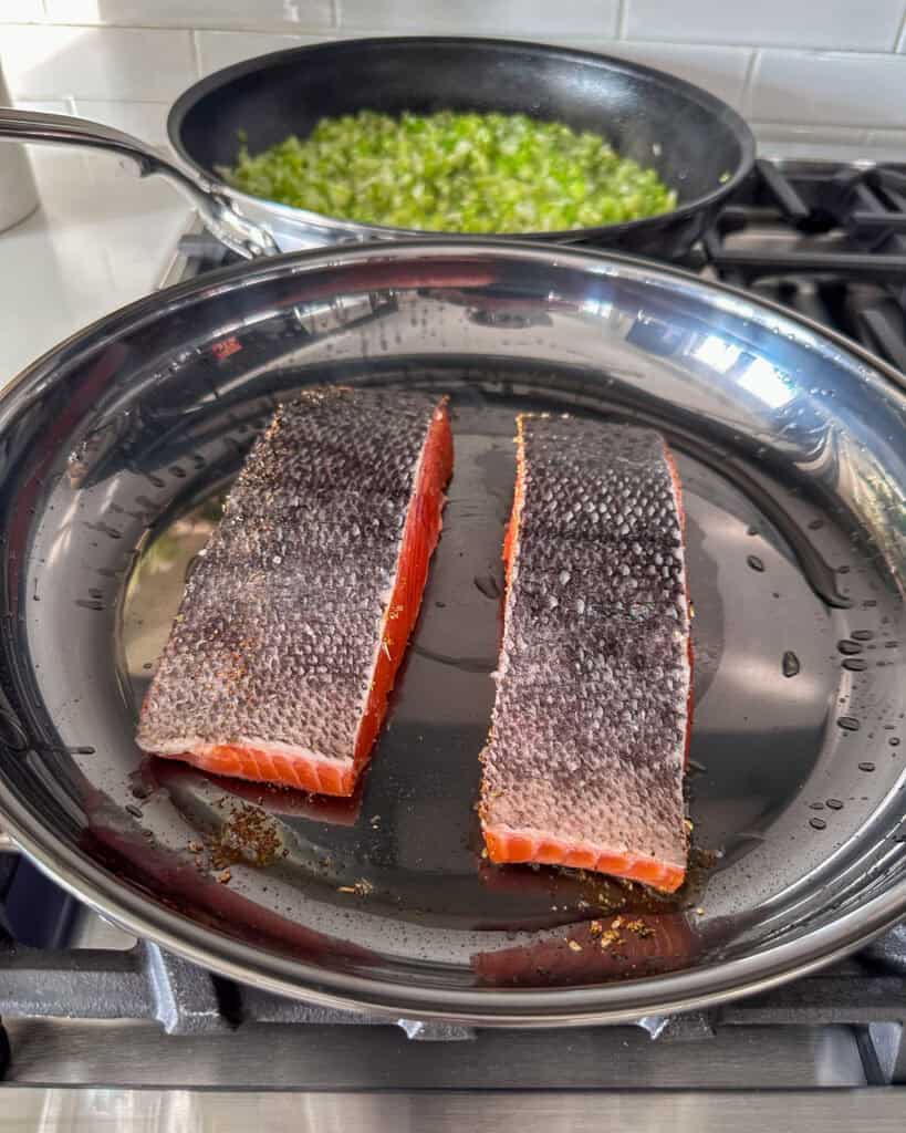 Place the seasoned, flesh side of the salmon down in the skillet.
