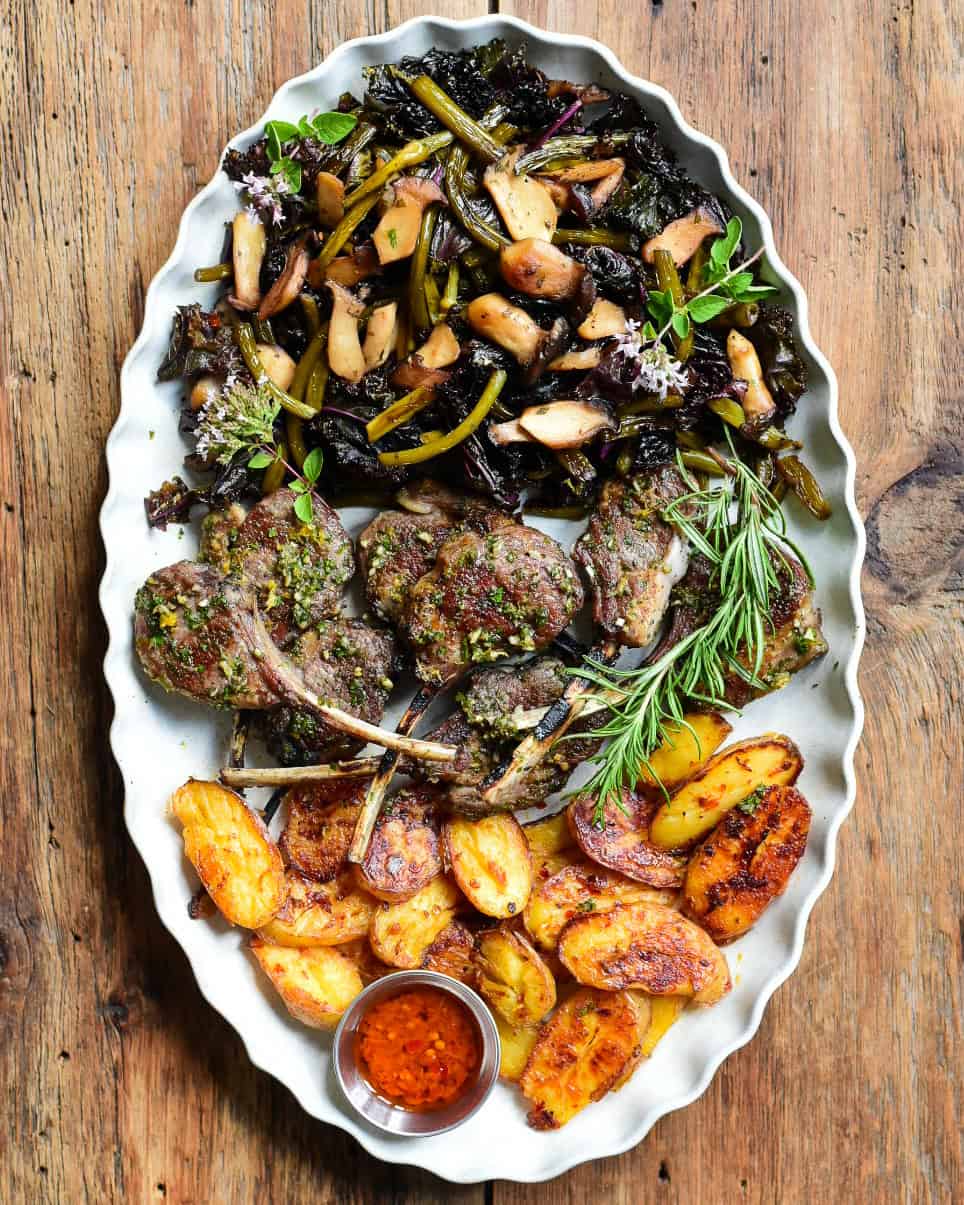 Lamb chops served with potatoes and sauteed vegetables.