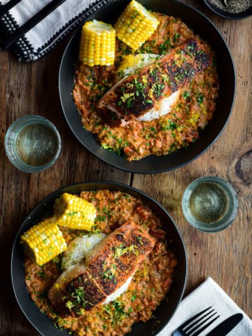 Two bowls of Blackened Salmon with a creamy Creole Sauce with rice and corn.