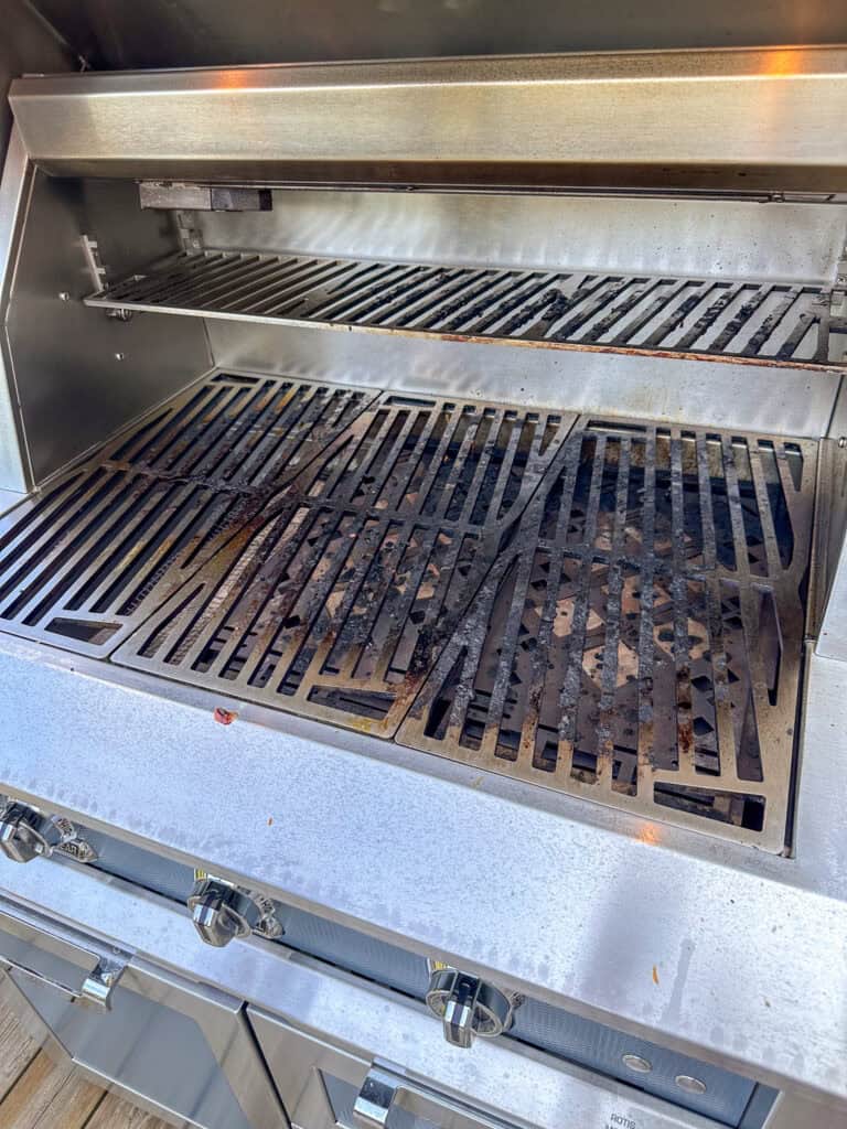 A close up of dirty grill grates on a grill.