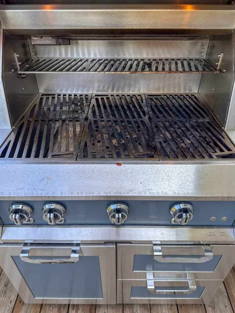 An open grill with dirty grates.