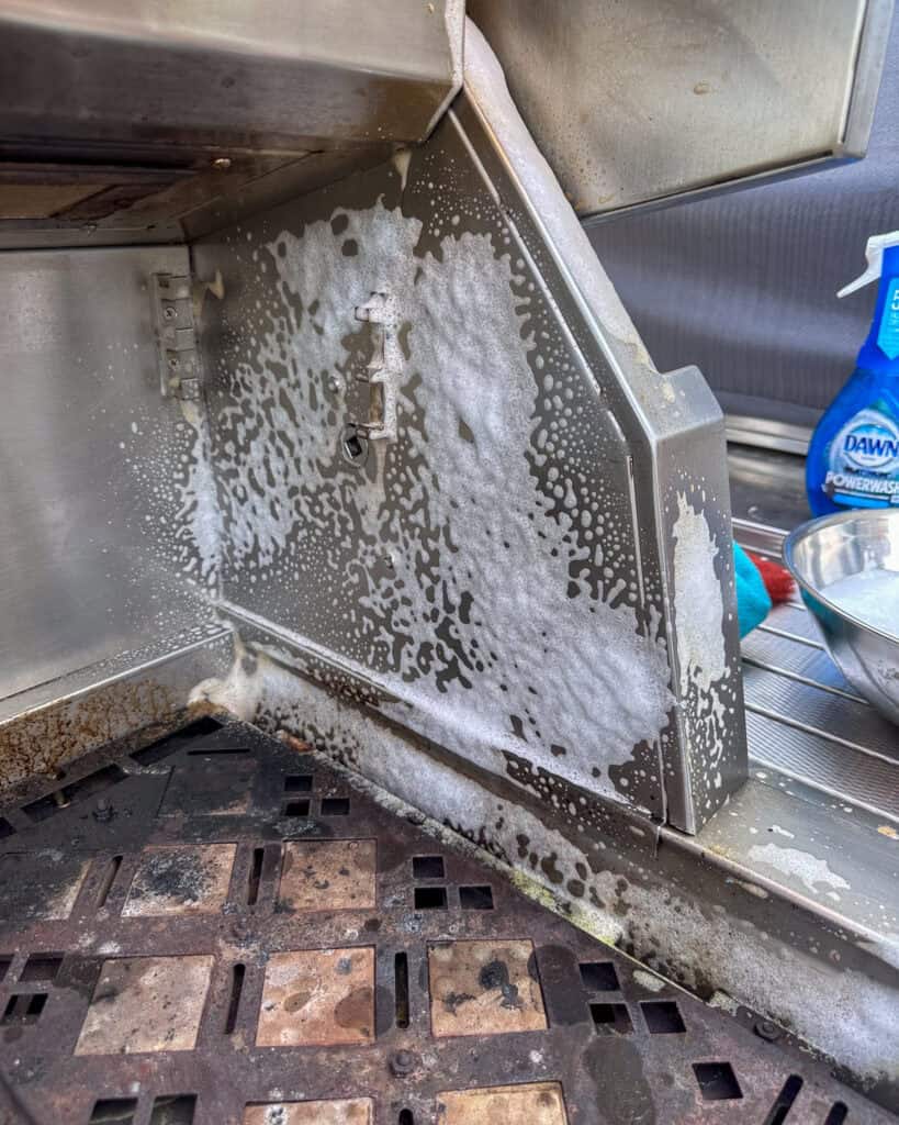 Cleaning inside of gas grill using Dawn Powerwash.
