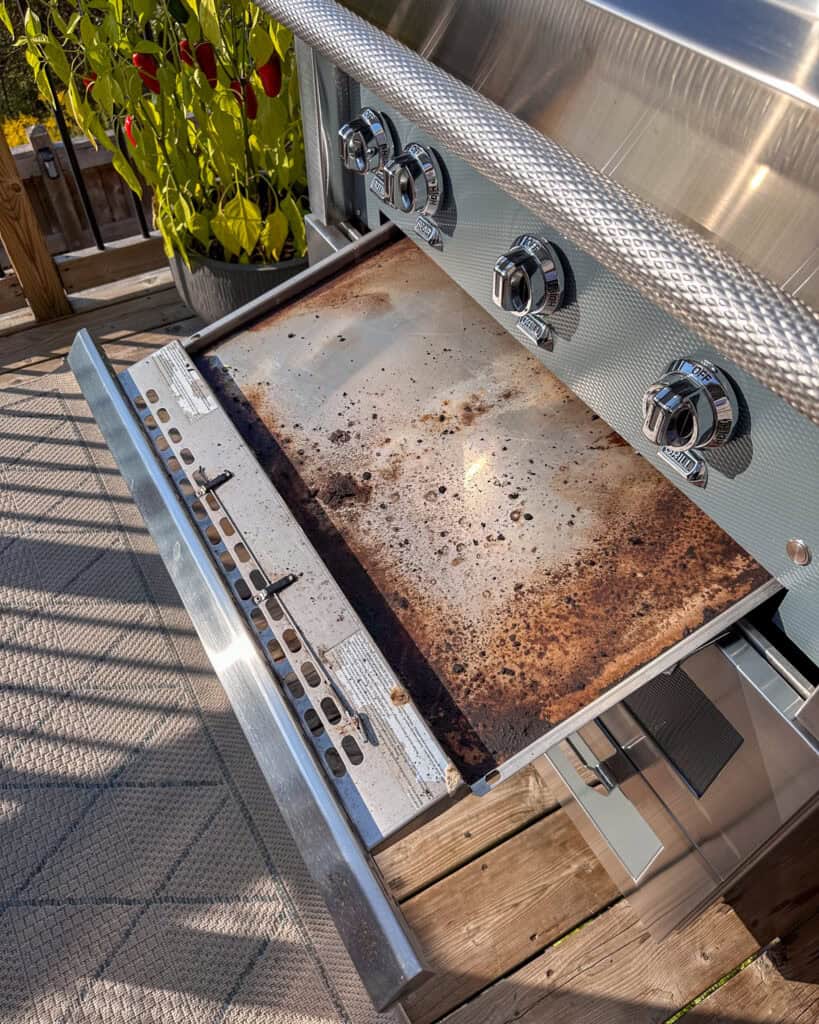 How to clean a gas grill drip pan - carefully remove the tray from the grill.