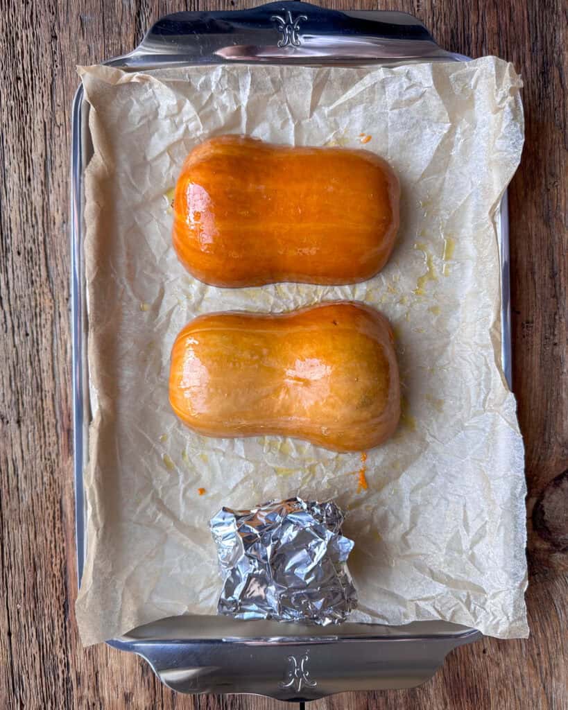 Two honeynut squash cut in half, cut side down and brushed with oil to roast.