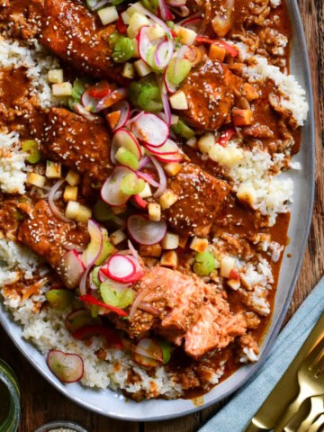 A plater with Baked Curry Salmon with Coconut Rice and and apple salsa.