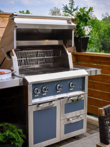 A clean Hestan gas grill with the lid open.