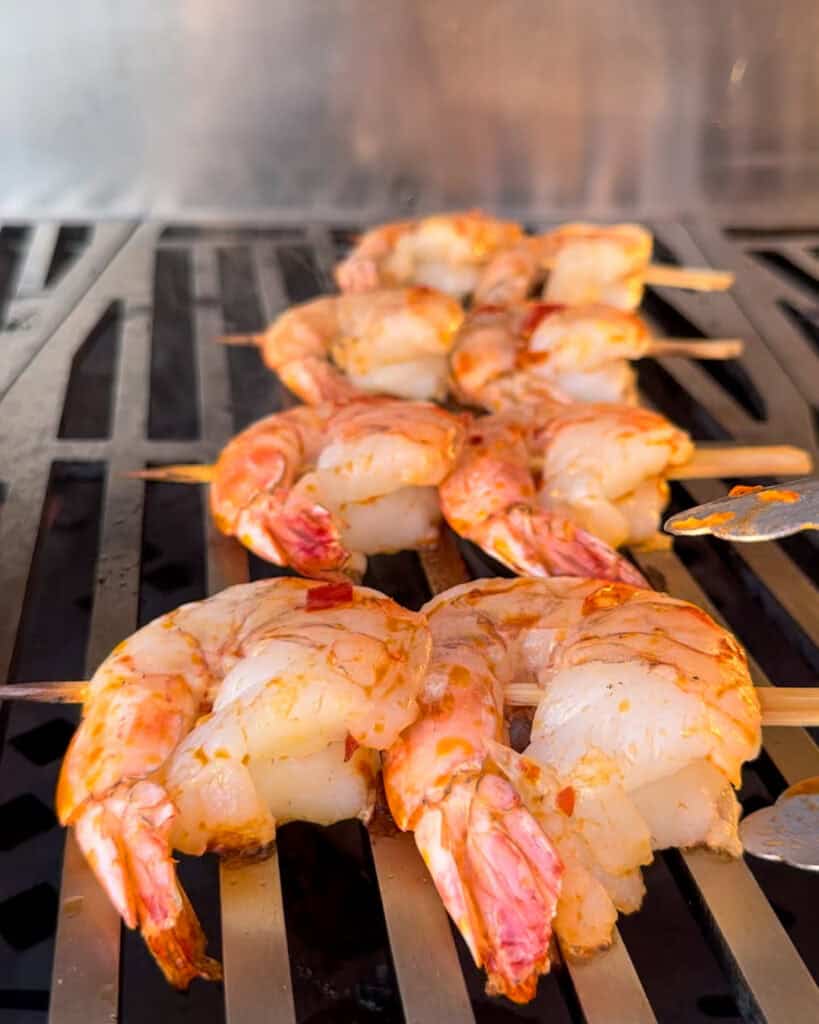 Skewered shrimp on the grill brushed with chili oil.