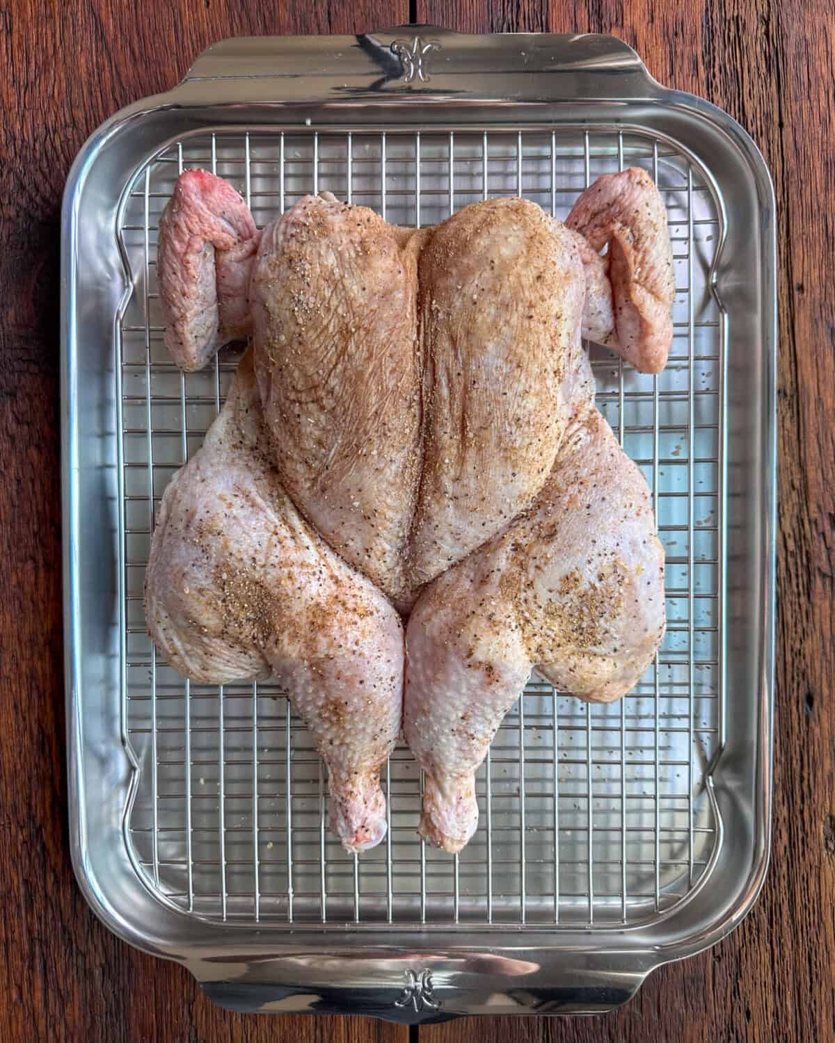 A spatchcock chicken with a seasoning rub all over it.