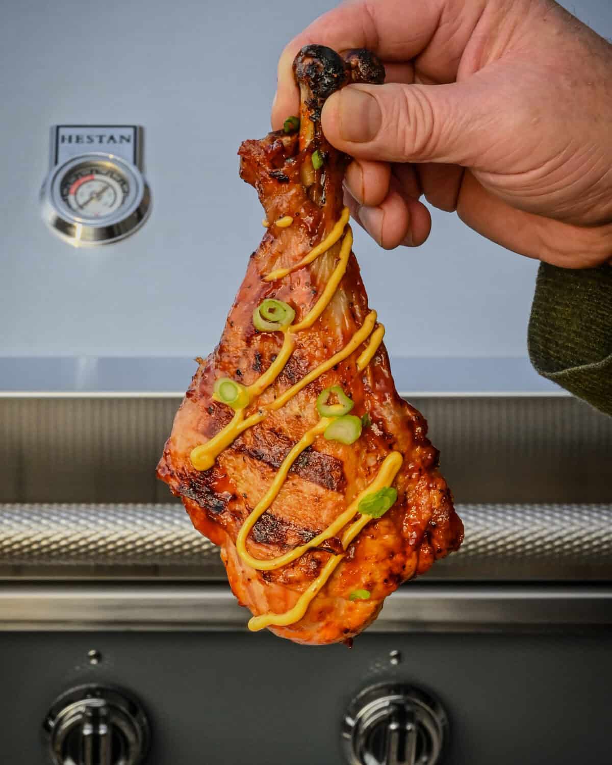 A butterflied turkey leg with grill marks and drizzed with habinero aioli sauce.