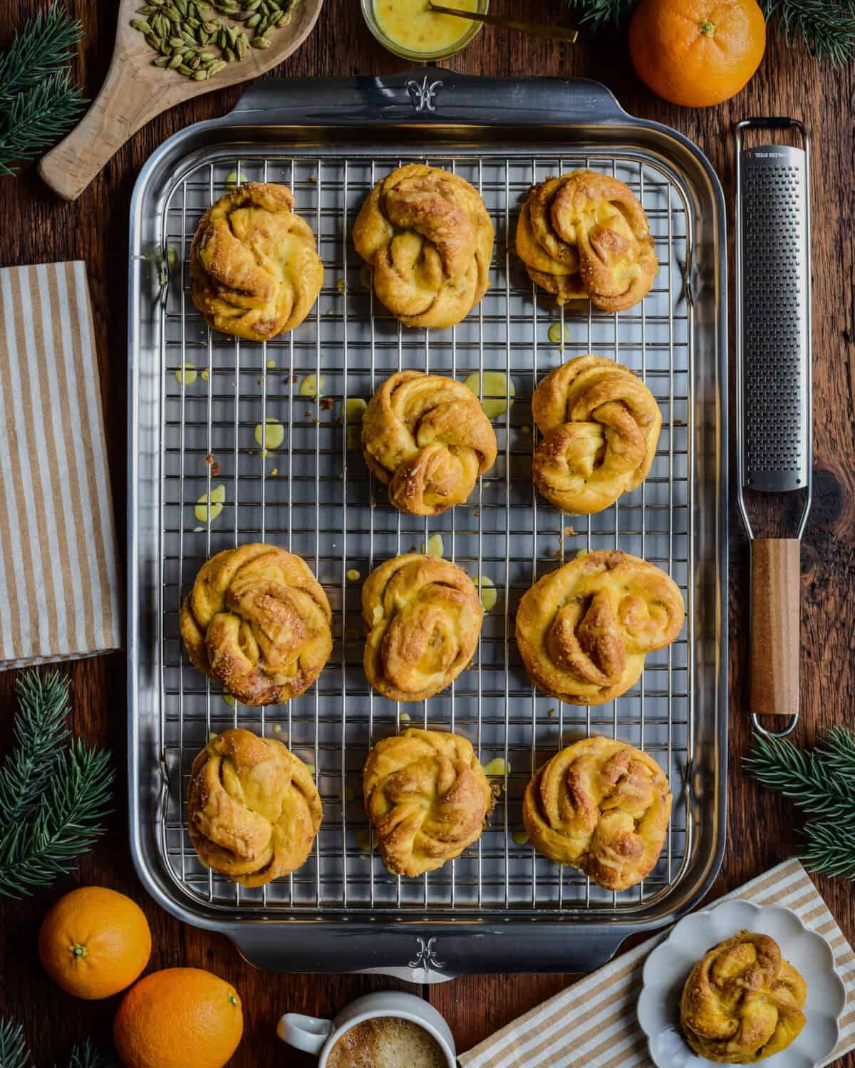 A sheet pan with Orange Cardamom Buns surrounded in a festive setting.