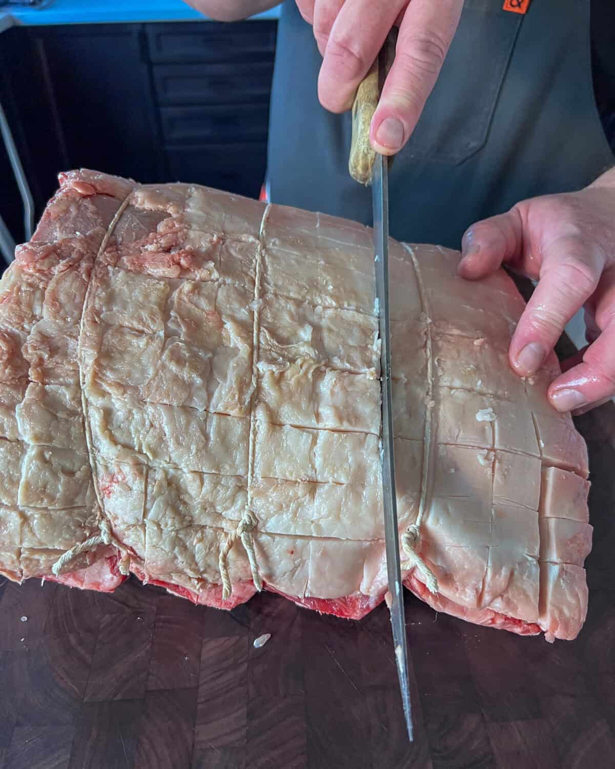 Using a sharp knife, lightly score the fat cap of the prime rib in a crisscross pattern.