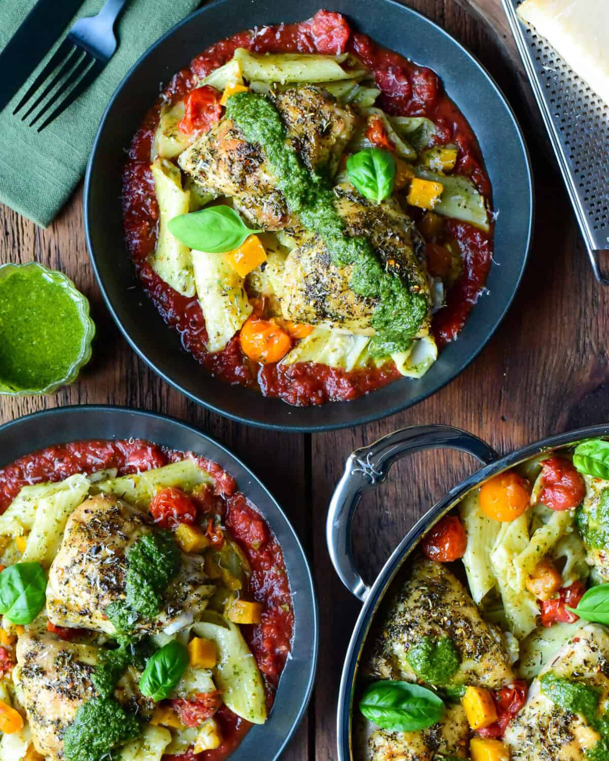 Two bowls of Baked Pesto Pasta & Chicken along with a saute pan.