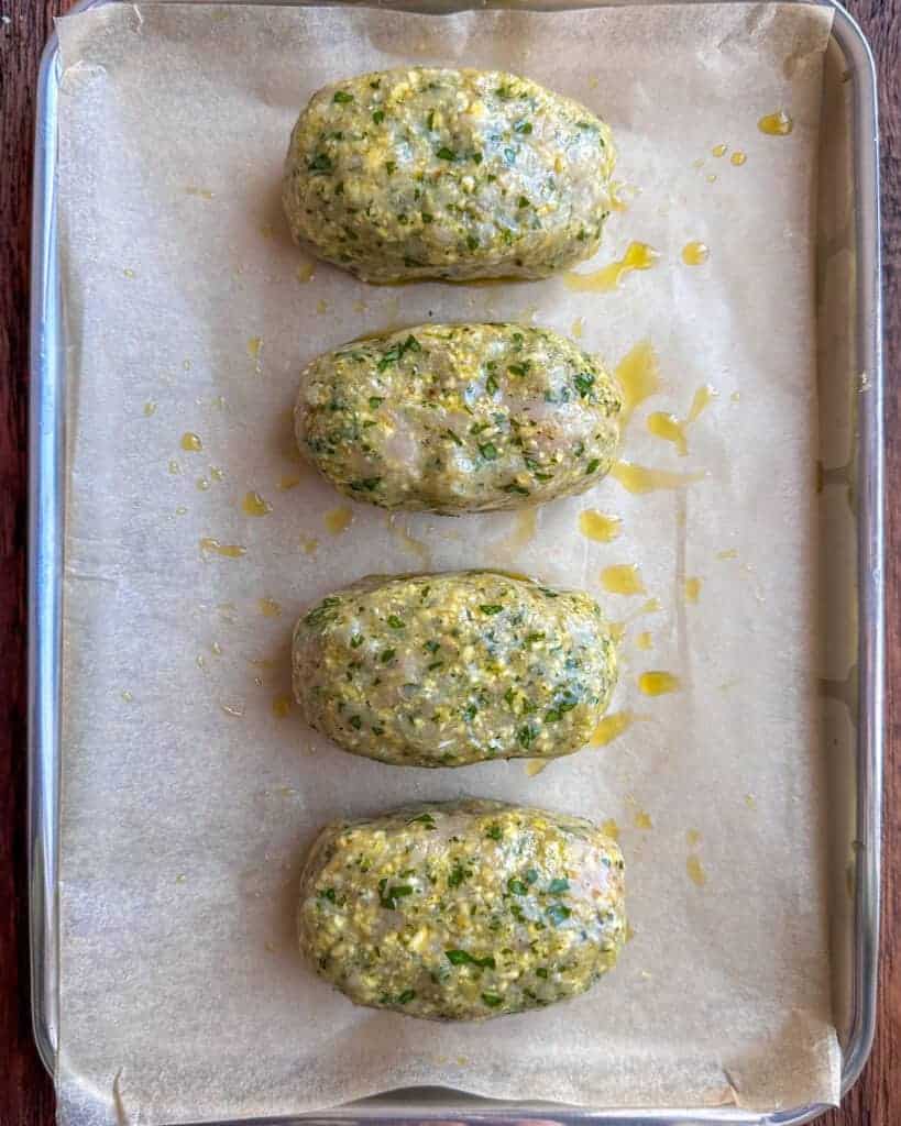 Shape the mixture into four mini turkey meatloaves, then brush olive oil over the loaves and place them on a baking sheet.
