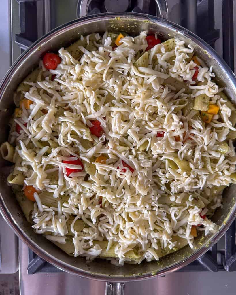 A layer of shredded cheese ove a pesta pasta about to get baked.